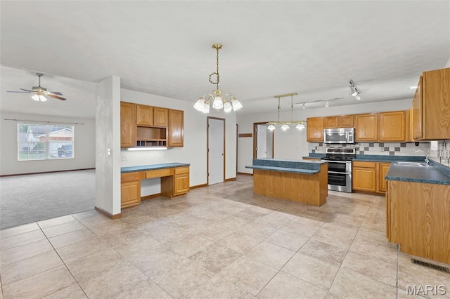 3779 Michael John Dr, Swansea, IL 62226 - kitchen with appliances with stainless steel finishes, built in study area, a center island, light tile patterned floors, and dark countertops