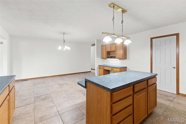 3779 Michael John Dr, Swansea, IL 62226 - kitchen with a chandelier, dark countertops, light tile patterned floors, hanging light fixtures, and a center island