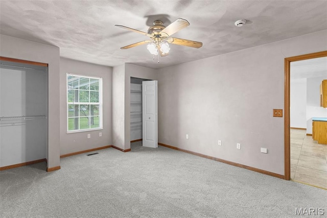 3779 Michael John Dr, Swansea, IL 62226 - unfurnished bedroom with multiple closets, light colored carpet, and a ceiling fan