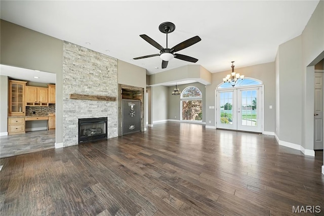 1408 Elm Tree Rd, Troy, MO 63379 - unfurnished living room featuring a chandelier, wood finished floors, a ceiling fan, a towering ceiling, and a stone fireplace