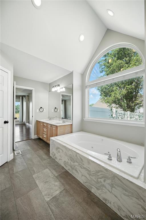 1408 Elm Tree Rd, Troy, MO 63379 - full bath with lofted ceiling, vanity, a whirlpool tub, and recessed lighting