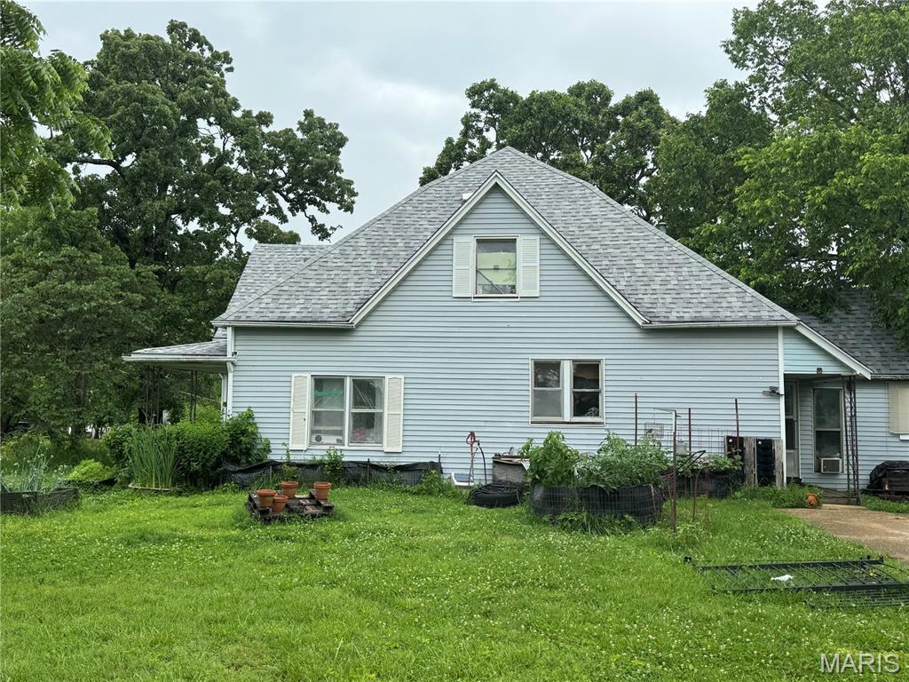 402 N Chestnut St, Richland, MO 65556 - rear view of house with a shingled roof and a yard