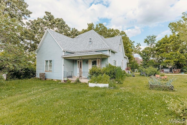 402 N Chestnut St, Richland, MO 65556 - view of front facade with covered porch, roof with shingles, and a front lawn