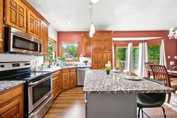 5 Sherman Ct, Hillsboro, MO 63050 - kitchen with stainless steel appliances, a textured ceiling, healthy amount of natural light, and brown cabinetry