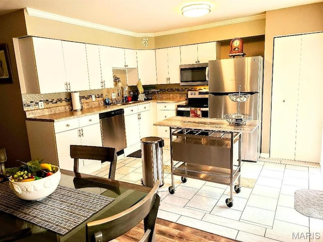 7540 Hazelcrest Dr, Hazelwood, MO 63042 - kitchen featuring stainless steel appliances, crown molding, white cabinetry, tasteful backsplash, and light countertops