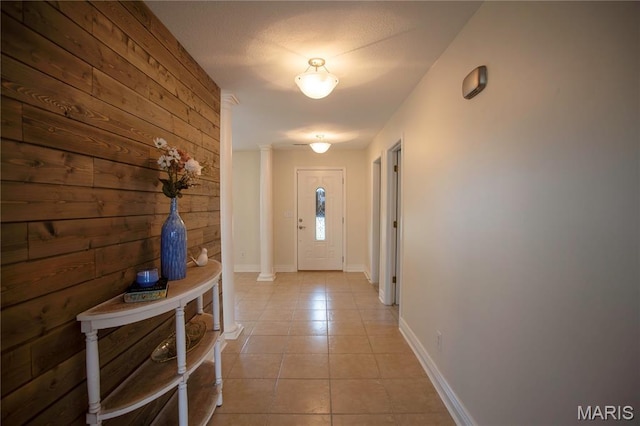 1106 Tulip Trce, Sikeston, MO 63801 - doorway to outside with light tile patterned flooring, wooden walls, and decorative columns