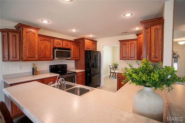 1106 Tulip Trce, Sikeston, MO 63801 - kitchen featuring black appliances, a breakfast bar, brown cabinets, light countertops, and recessed lighting