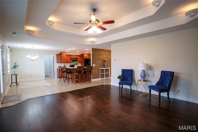 1106 Tulip Trce, Sikeston, MO 63801 - living area featuring a raised ceiling, a chandelier, a ceiling fan, and light wood finished floors