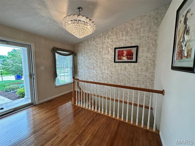 17 Battersea Ct Unit 6B, Ofallon, MO 63366 - foyer featuring a chandelier, wood finished floors, healthy amount of natural light, and a textured ceiling