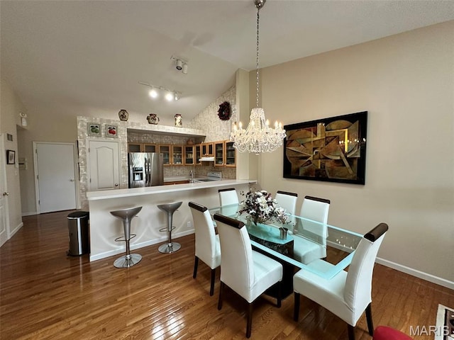 17 Battersea Ct Unit 6B, Ofallon, MO 63366 - dining space featuring lofted ceiling, wood finished floors, a chandelier, and track lighting