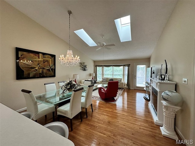 17 Battersea Ct Unit 6B, Ofallon, MO 63366 - dining area featuring a skylight, wood finished floors, a chandelier, and lofted ceiling