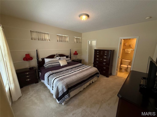 17 Battersea Ct Unit 6B, Ofallon, MO 63366 - bedroom with light colored carpet, a textured ceiling, and connected bathroom