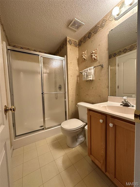 17 Battersea Ct Unit 6B, Ofallon, MO 63366 - full bathroom featuring a textured ceiling, vanity, a stall shower, and tile patterned flooring
