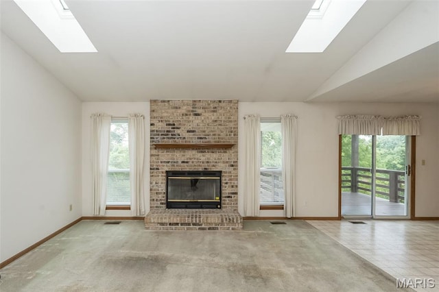 425 Bluffview Hts, Arnold, MO 63010 - unfurnished living room featuring a skylight, plenty of natural light, vaulted ceiling, and a brick fireplace