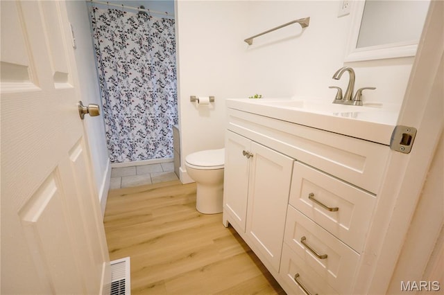 5444 Janet Ave, Jennings, MO 63136 - bathroom with wood finished floors, vanity, and a shower with shower curtain