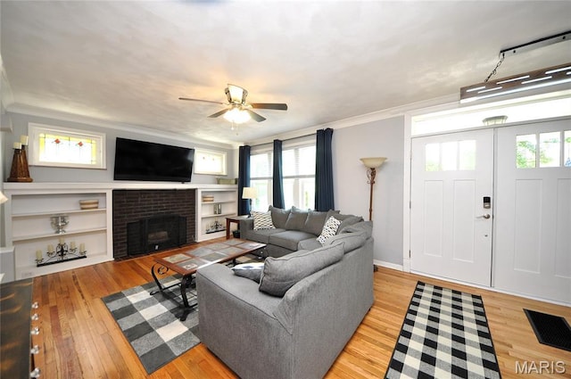 5241 Devonshire Ave, Saint Louis, MO 63109 - living area with a ceiling fan, light wood-style floors, ornamental molding, healthy amount of natural light, and a brick fireplace