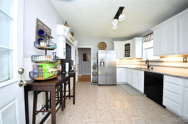 5241 Devonshire Ave, Saint Louis, MO 63109 - kitchen with stainless steel refrigerator with ice dispenser, black dishwasher, white cabinets, and light stone counters
