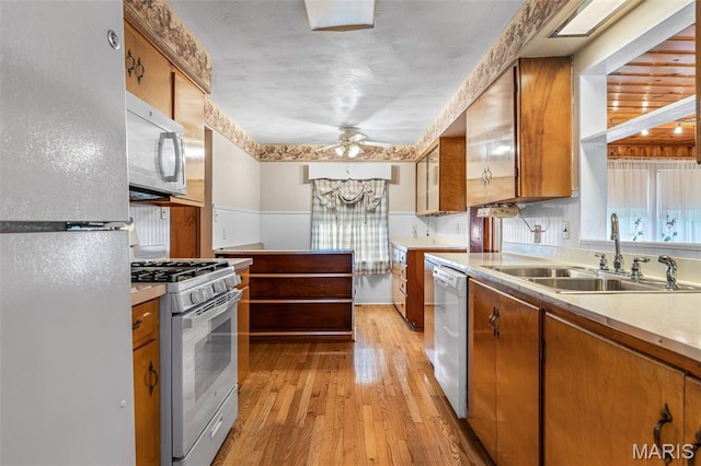 715 S A St, Farmington, MO 63640 - kitchen with white appliances, light wood-style floors, ceiling fan, and brown cabinetry