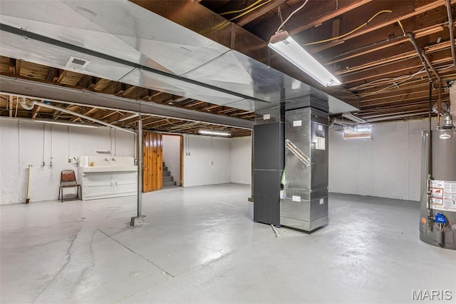 715 S A St, Farmington, MO 63640 - unfinished below grade area featuring gas water heater, stairway, and heating unit