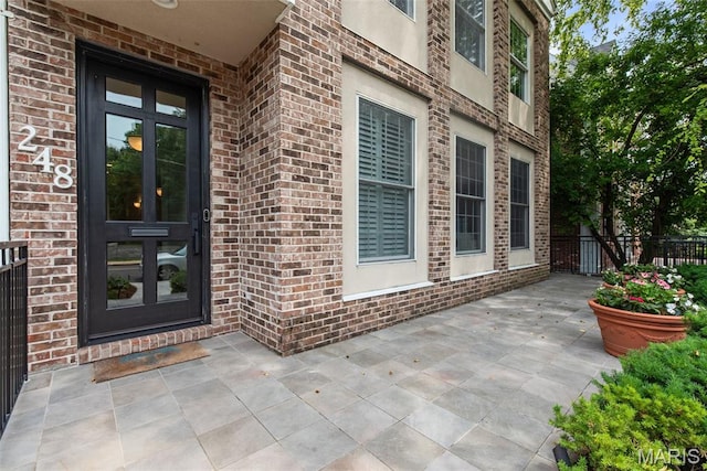 248 Gay Ave, Clayton, MO 63105 - doorway to property featuring brick siding and a patio area