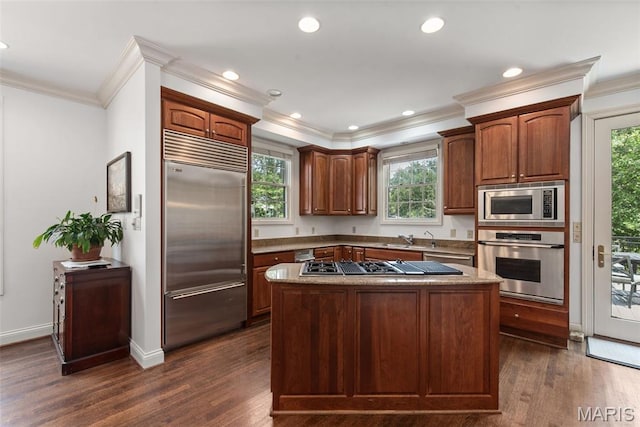 248 Gay Ave, Clayton, MO 63105 - kitchen with built in appliances, ornamental molding, dark wood-style floors, a center island, and plenty of natural light