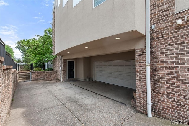 248 Gay Ave, Clayton, MO 63105 - view of side of property featuring a garage, brick siding, concrete driveway, and stucco siding