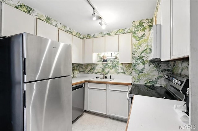 4501 Lindell Blvd Unit 9A, Saint Louis, MO 63108 - kitchen featuring appliances with stainless steel finishes, wallpapered walls, light countertops, and light flooring