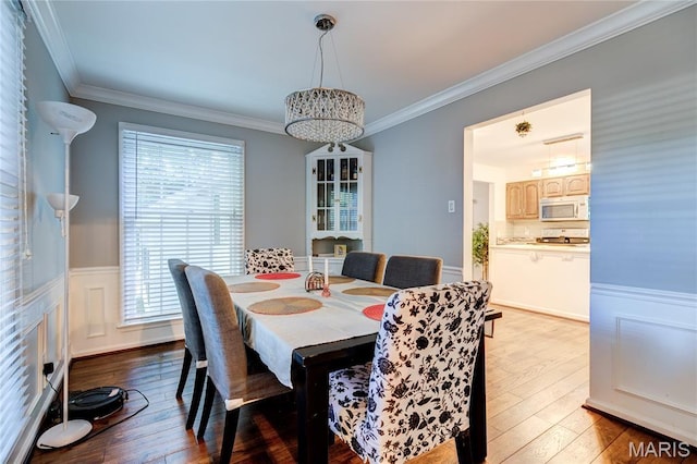 67 Kings Dr, Florissant, MO 63034 - dining area with plenty of natural light, crown molding, hardwood / wood-style flooring, wainscoting, and a chandelier
