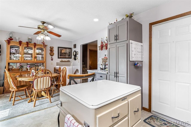 1301 Camillia St, Farmington, MO 63640 - kitchen featuring gray cabinets, ceiling fan, light countertops, a kitchen island, and a textured ceiling