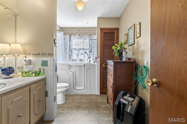 1301 Camillia St, Farmington, MO 63640 - bathroom featuring vanity, curtained shower, tile walls, and a textured ceiling