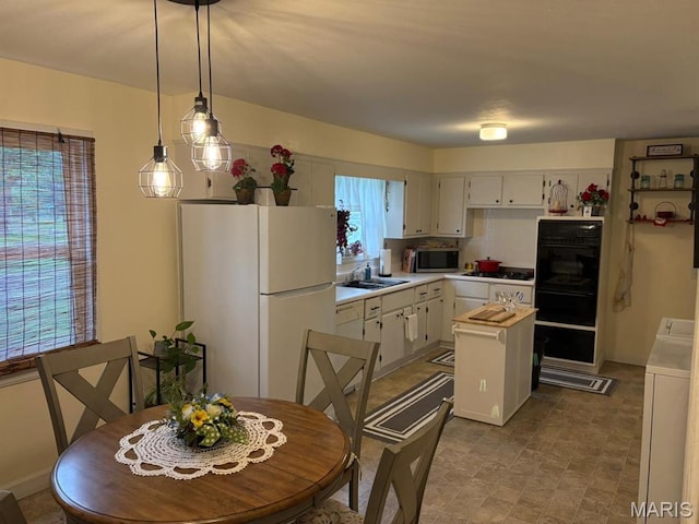 422 W Dover St, Monroe City, MO 63456 - kitchen featuring black appliances, light countertops, a kitchen island, pendant lighting, and white cabinets