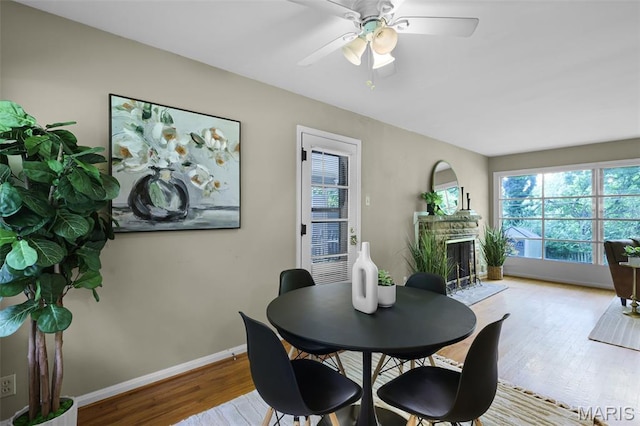 450 Forest Green Dr, Webster Groves, MO 63119 - dining area with a brick fireplace, wood finished floors, and a ceiling fan