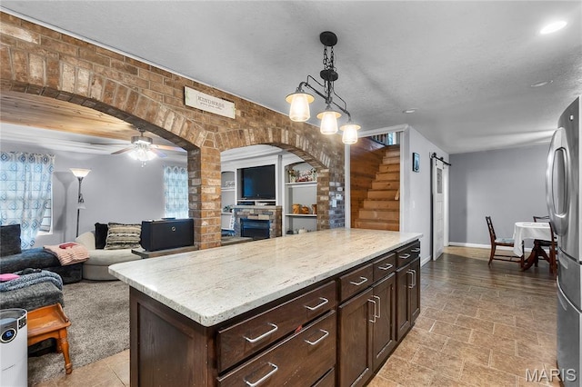 115 Whitener St, Marquand, MO 63655 - kitchen featuring open floor plan, hanging light fixtures, freestanding refrigerator, ceiling fan, and dark brown cabinets