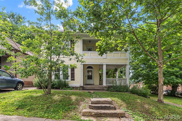 325 N Lorimier St, Cape Girardeau, MO 63701 - view of property hidden behind natural elements with a balcony, stucco siding, a porch, and a front lawn