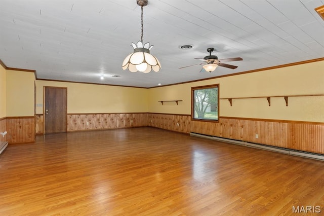 201 E Old Route 66, Mount Olive, IL 62069 - spare room featuring light wood-style flooring, a wainscoted wall, crown molding, a baseboard radiator, and a ceiling fan