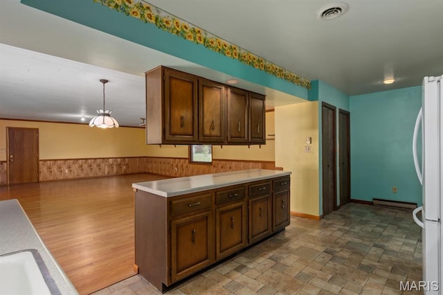 201 E Old Route 66, Mount Olive, IL 62069 - kitchen with freestanding refrigerator, light countertops, a wainscoted wall, hanging light fixtures, and baseboard heating