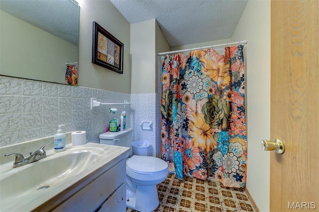 6048 La Chateau Ct, Saint Louis, MO 63129 - bathroom featuring a textured ceiling, vanity, a shower with shower curtain, tile walls, and wainscoting