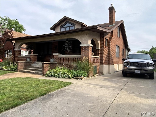 218 W 6th St, Hermann, MO 65041 - view of front facade featuring covered porch, brick siding, a chimney, and driveway