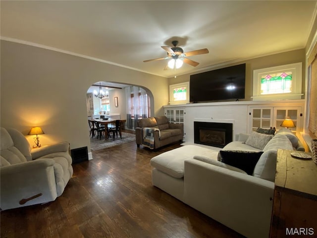 218 W 6th St, Hermann, MO 65041 - living area with arched walkways, crown molding, dark wood-style flooring, a ceiling fan, and a fireplace