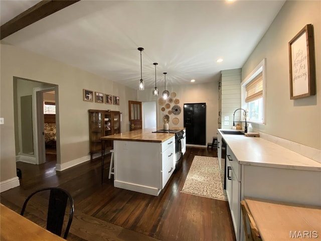 218 W 6th St, Hermann, MO 65041 - kitchen with wood counters, white cabinetry, dark wood finished floors, recessed lighting, and a kitchen bar