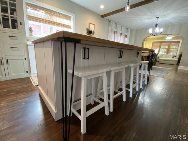 218 W 6th St, Hermann, MO 65041 - bar with arched walkways, dark wood-style floors, a chandelier, hanging light fixtures, and recessed lighting