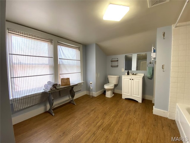 218 W 6th St, Hermann, MO 65041 - full bath with vanity, wood finished floors, healthy amount of natural light, washtub / shower combination, and lofted ceiling