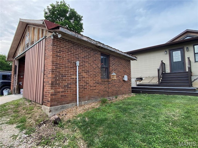 218 W 6th St, Hermann, MO 65041 - view of home's exterior featuring brick siding, a lawn, and entry steps