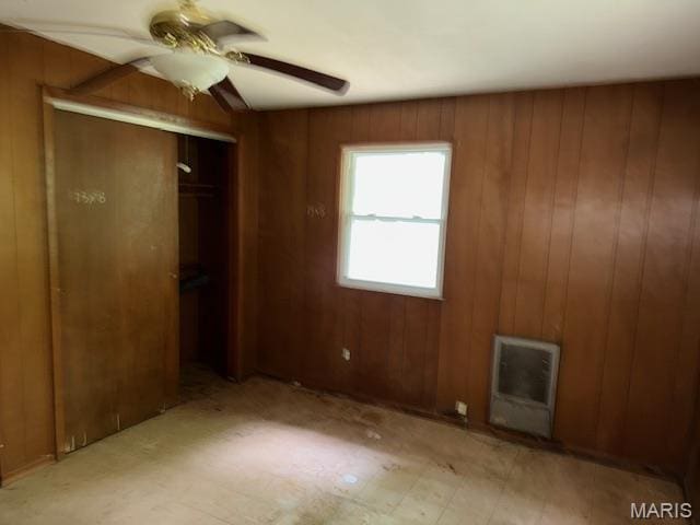 207 Hunter St, Lebanon, IL 62254 - unfurnished bedroom with heating unit, wooden walls, a closet, and a ceiling fan