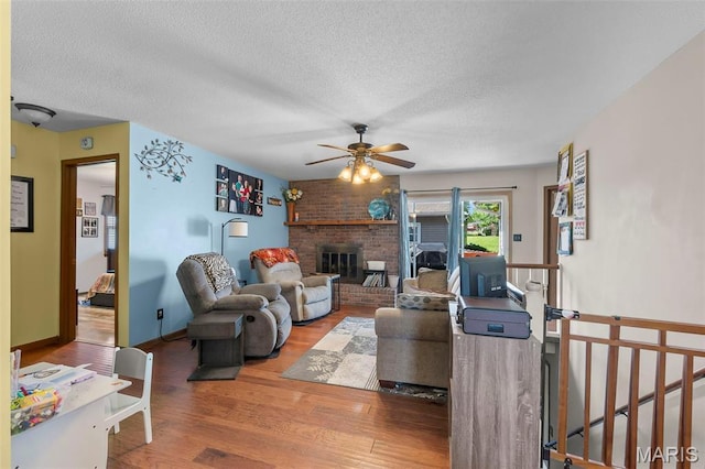 1802 Old Cape Rd, Jackson, MO 63755 - living area featuring wood finished floors, a ceiling fan, a textured ceiling, and a brick fireplace