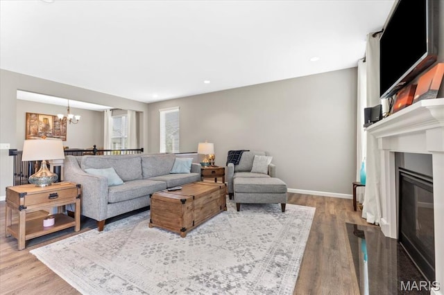 2333 Cabric Dr, Saint Charles, MO 63301 - living room featuring a chandelier, wood finished floors, and a fireplace with flush hearth