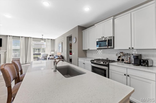 2333 Cabric Dr, Saint Charles, MO 63301 - kitchen with appliances with stainless steel finishes, open floor plan, decorative backsplash, a center island with sink, and recessed lighting