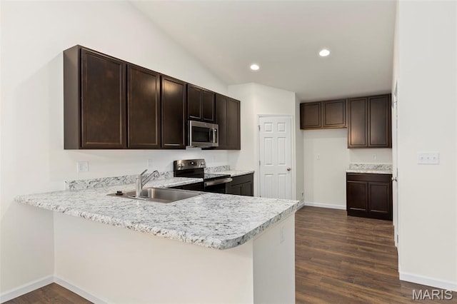 262 Liberty Valley Dr, Foristell, MO 63348 - kitchen with stainless steel appliances, light countertops, dark brown cabinets, dark wood finished floors, and a peninsula