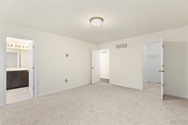 262 Liberty Valley Dr, Foristell, MO 63348 - unfurnished bedroom with light carpet, a walk in closet, ensuite bath, and a closet