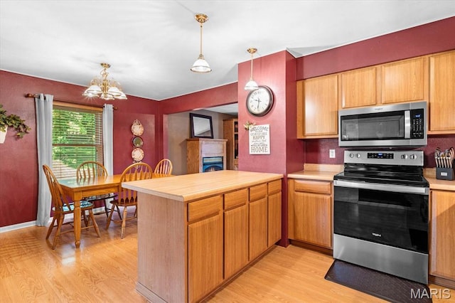 334 Hazel Ave, Belleville, IL 62223 - kitchen with appliances with stainless steel finishes, light wood-style flooring, a peninsula, and light countertops